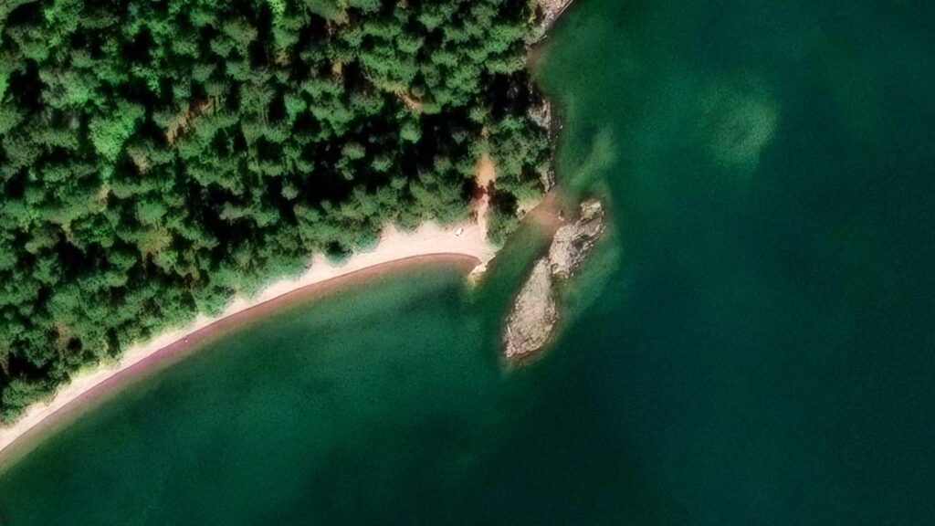 Skärberget med sandstranden intill, sett från luften.